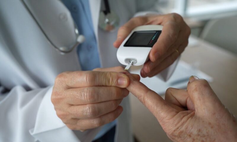 doktor vadi krv i meri šećer starijoj osobi