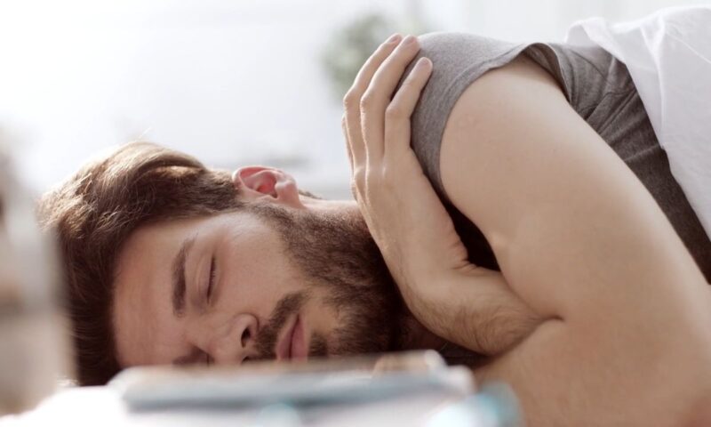 momak leži na krevetu i spava